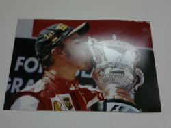 Fernando Alonso Kissing A Trophy On The Podium When He Was Still At Ferrari.
